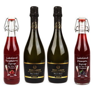 Picture of the contents of Lakeland Artisan's Christmas Fizz Box: 2 bottles of Jules Larose Blanc de Blancs sparkling white wine in the centre, with a swing top bottle of Lakeland Raspberry Syrup on the left and a bottle of the Lakeland Damson Syrup to the right, all set against a white background.